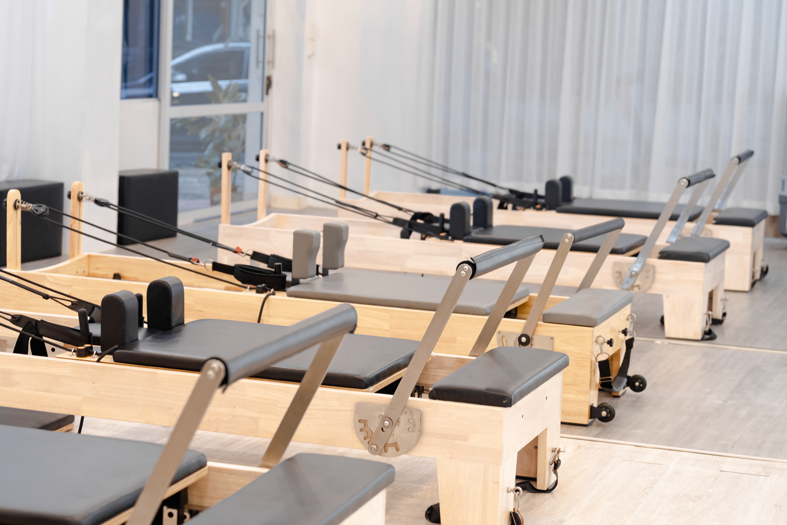 Um estúdio contemporâneo de Pilates equipado com vários reformadores de madeira para treinamento físico.